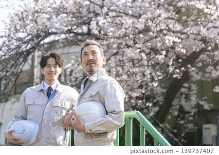 A group of male workers standing in front of a cherry tree. A group of male workers standing in front of a cherry tree. 139737407