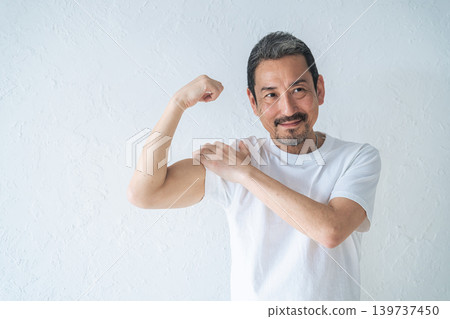 A middle-aged man showing off his biceps A middle-aged man showing off his biceps 139737450