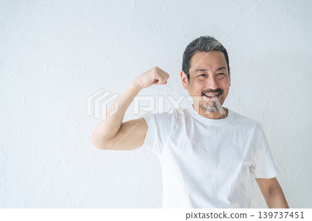 A middle-aged man showing off his biceps A middle-aged man showing off his biceps 139737451