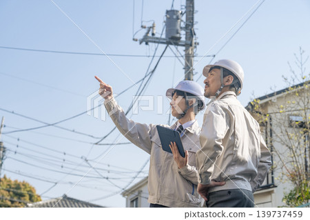 A group of male workers standing in a residential area 139737459