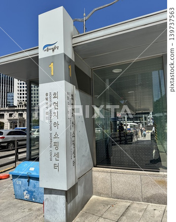Entrance 1 of the Hoehyeon Underground Shopping Center (Hoehyeon Underground Shopping Arcade) in Seoul, South Korea, and a view of the city on a sunny day. 139737563