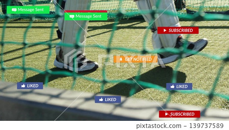 Stepping two players' lower legs wearing cricket leg pads and shoes inside green net, social badges Stepping two players' lower legs wearing cricket leg pads and shoes inside green net, social badges 139737589