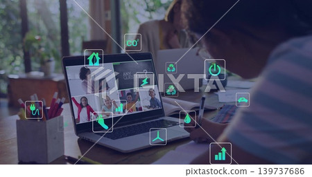 Writing child in striped shirt holding pen referencing laptop call at wood table, with energy icons Writing child in striped shirt holding pen referencing laptop call at wood table, with energy icons 139737686