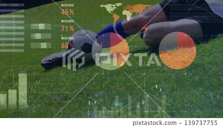 Sliding soccer player wearing blue socks, shin guard on grass pitch, showing data overlay and ball 139737755