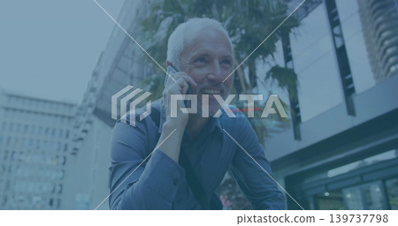 Talking Senior man in dark blue shirt holding smartphone to ear on downtown street, bag strap 139737798