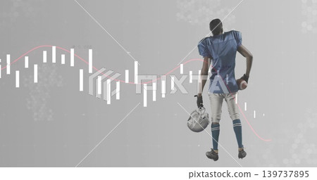 Standing football player wearing blue gear in studio, holding helmet, football, chart, copy space Standing football player wearing blue gear in studio, holding helmet, football, chart, copy space 139737895