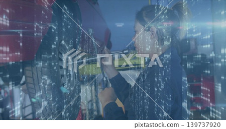 Working mechanic using lug-wrench on red car wheel in garage on lift in navy-coveralls, copy space Working mechanic using lug-wrench on red car wheel in garage on lift in navy-coveralls, copy space 139737920