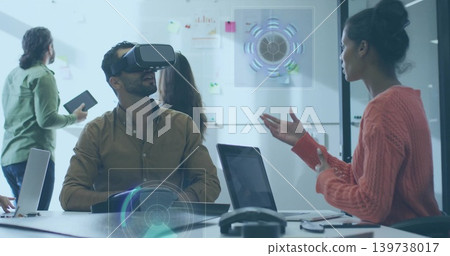 Exploring man wearing VR headset, button shirt navigating AR UI at meeting table with laptops Exploring man wearing VR headset, button shirt navigating AR UI at meeting table with laptops 139738017