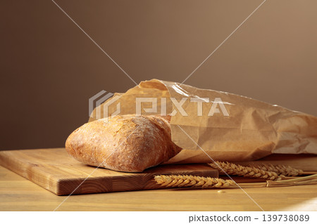 Fresh backed ciabatta bread in paper bag on a wooden table. 139738089