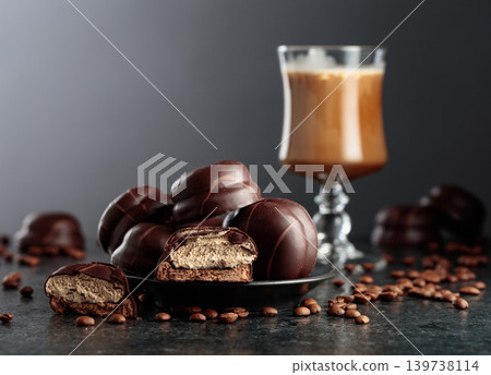 Chocolate dessert and cup of coffee with cream on a black table. 139738114