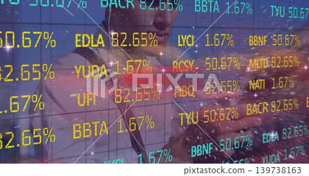 Leaning professional in suit and dark tie at office, interacting with tablet and market tickers Leaning professional in suit and dark tie at office, interacting with tablet and market tickers 139738163