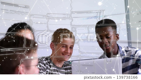 Smiling blond student in striped tee with peers leaning over laptop at lab, with digital overlay 139738166