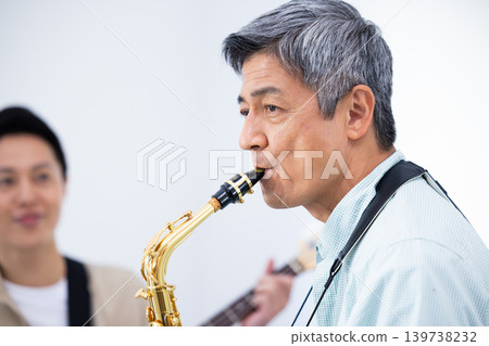 一位家長和孩子正在演奏樂器:薩克斯風和貝斯即興演奏。 一位家長和孩子正在演奏樂器:薩克斯風和貝斯即興演奏。 139738232
