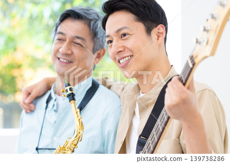 A parent and child playing musical instruments: a saxophone and bass jam session. A parent and child playing musical instruments: a saxophone and bass jam session. 139738286