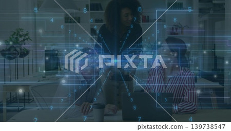 Leading woman in dark blazer leaning over office table, guiding team with laptop, digital overlay Leading woman in dark blazer leaning over office table, guiding team with laptop, digital overlay 139738547
