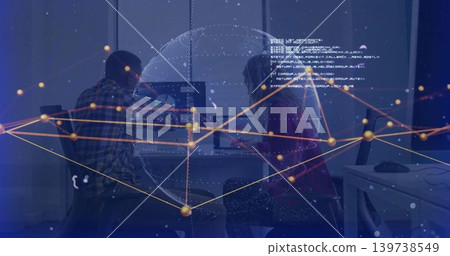 Collaborating coworkers in plaid shirt and dark top working in office with holo globe over screens Collaborating coworkers in plaid shirt and dark top working in office with holo globe over screens 139738549