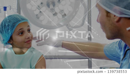 Reaching gloved doc in scrubs touching teal-capped child on bed under overhead light, copy space Reaching gloved doc in scrubs touching teal-capped child on bed under overhead light, copy space 139738553