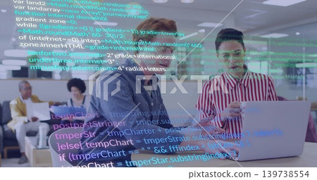 Discussing two males in navy and red shirts reviewing laptop code in office, with code overlay Discussing two males in navy and red shirts reviewing laptop code in office, with code overlay 139738554