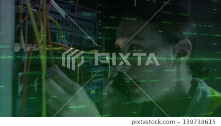 Fixing female tech wearing hi-vis vest, holding phone and rerouting Ethernet cables at server rack 139738615