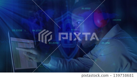 Pointing IT pro viewing laptop table in dim blue hub, shirt, red headset, shield numeric overlays Pointing IT pro viewing laptop table in dim blue hub, shirt, red headset, shield numeric overlays 139738681