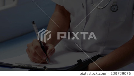 Writing mid-adult clinician filling patient form in clinic wearing white medical top and clipboard Writing mid-adult clinician filling patient form in clinic wearing white medical top and clipboard 139739076