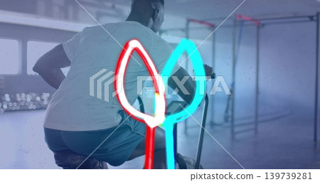 Pedaling athlete wearing white T-shirt and teal shorts on stationary bike at gym, neon overlay Pedaling athlete wearing white T-shirt and teal shorts on stationary bike at gym, neon overlay 139739281
