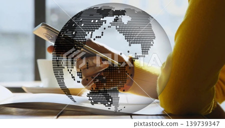 Holding right hand in yellow sweater tapping smartphone over open book at cafe table, dotted globe Holding right hand in yellow sweater tapping smartphone over open book at cafe table, dotted globe 139739347