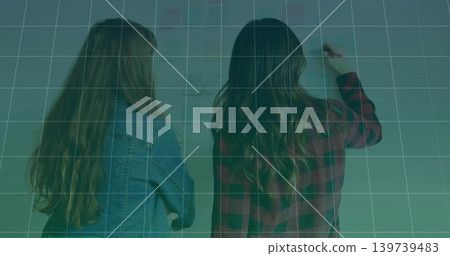 Writing two women working in classroom, marking wall with marker, denim jacket, plaid shirt, grid Writing two women working in classroom, marking wall with marker, denim jacket, plaid shirt, grid 139739483