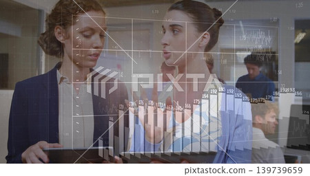 Analyzing two women in office attire examining financial charts on tablets with chart overlay Analyzing two women in office attire examining financial charts on tablets with chart overlay 139739659