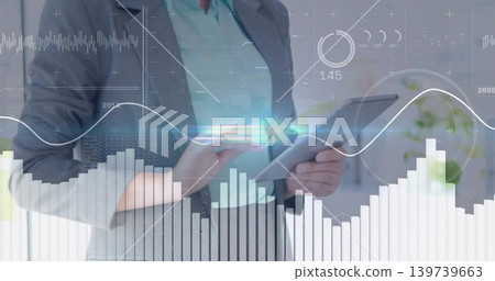 Holding woman executive in grey blazer teal blouse tapping tablet at desk, with data overlays Holding woman executive in grey blazer teal blouse tapping tablet at desk, with data overlays 139739663