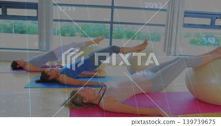 Doing stability-ball bridge, woman on pink mat lifting hips in leggings in studio with overlay grid Doing stability-ball bridge, woman on pink mat lifting hips in leggings in studio with overlay grid 139739675