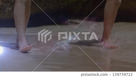 Wading two kids' bare feet in shallow shoreline water at beach, showing footprints and lens flare Wading two kids' bare feet in shallow shoreline water at beach, showing footprints and lens flare 139739722