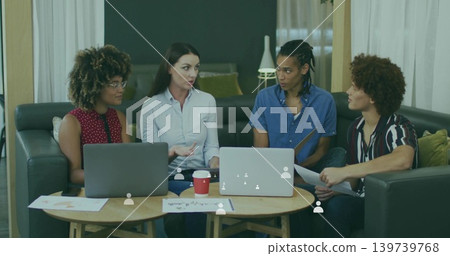 Discussing four adults blue shirt gesturing, collaborating in lounge with laptops and papers Discussing four adults blue shirt gesturing, collaborating in lounge with laptops and papers 139739768