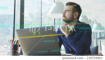 Gazing man in dark blue shirt, resting chin, viewing laptop with financial charts, copy space Gazing man in dark blue shirt, resting chin, viewing laptop with financial charts, copy space 139739903