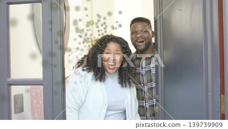 Smiling woman and man standing in home entryway, wearing sweater and plaid shirt, showing sidelight Smiling woman and man standing in home entryway, wearing sweater and plaid shirt, showing sidelight 139739909