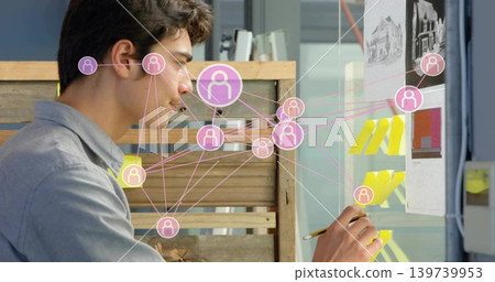 Arranging designer in gray shirt organizing yellow notes on glass board at studio with pink overlay Arranging designer in gray shirt organizing yellow notes on glass board at studio with pink overlay 139739953