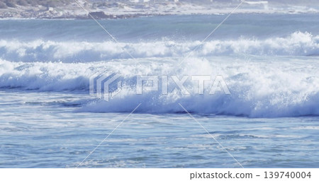 Breaking ocean waves moving toward shore at surf zone, with white foam and rocky shoreline Breaking ocean waves moving toward shore at surf zone, with white foam and rocky shoreline 139740004