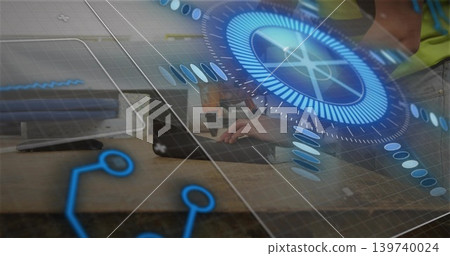 Typing two men wearing hi-vis vest leaning on laptop at workbench with AR circular UI overlay Typing two men wearing hi-vis vest leaning on laptop at workbench with AR circular UI overlay 139740024