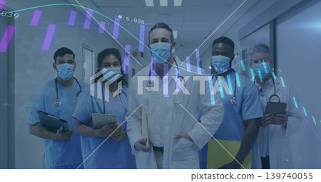 Standing male doctor in white coat holding file in hospital corridor, masked team and data overlay Standing male doctor in white coat holding file in hospital corridor, masked team and data overlay 139740055