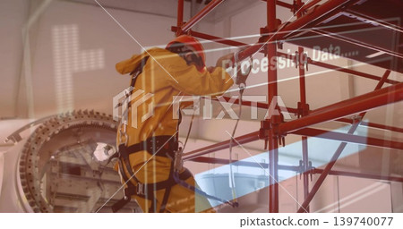 Climbing tech in yellow suit red helmet working on turbine scaffold in hangar with harness overlay Climbing tech in yellow suit red helmet working on turbine scaffold in hangar with harness overlay 139740077