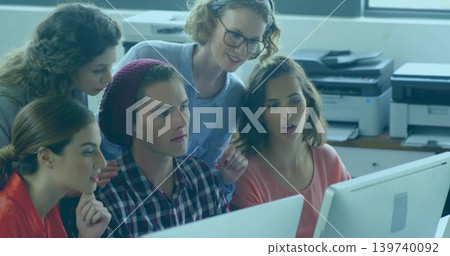 Collaborating five coworkers leaning over dual monitors in office, plaid shirt, printers behind Collaborating five coworkers leaning over dual monitors in office, plaid shirt, printers behind 139740092