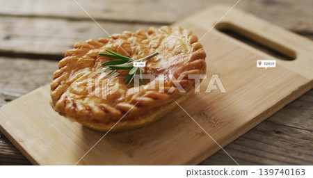 Displaying round pie featuring braided crust and rosemary on cutting board with handle, label icons Displaying round pie featuring braided crust and rosemary on cutting board with handle, label icons 139740163