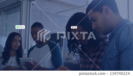 Leaning team in casual business attire, viewing tablet and phones in office, showing badges 139740224