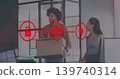 Holding cardboard box, man facing colleague in sleeveless top in open office with red overlays 139740314
