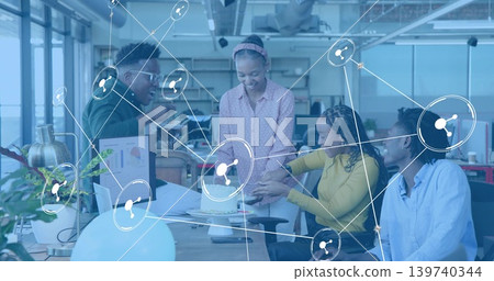 Gathering four colleagues wearing business attire around small cake at desk with digital overlay Gathering four colleagues wearing business attire around small cake at desk with digital overlay 139740344