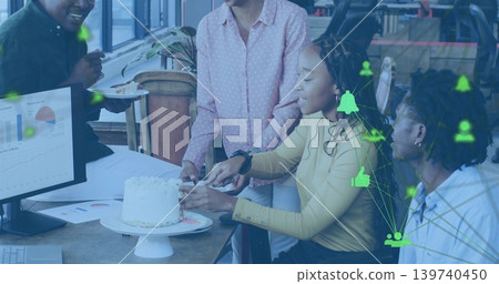 Cutting team serving cake at office desk, wearing pink and mustard top, monitor showing icons Cutting team serving cake at office desk, wearing pink and mustard top, monitor showing icons 139740450