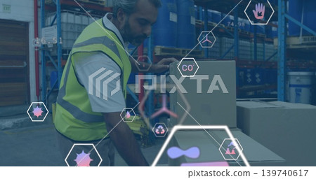 Leaning worker wearing hi-vis vest handling boxes with pallet jack at loading bay, with AR icons 139740617
