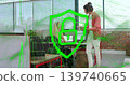 Leaning female in pink sweater showing device to seated male at open office, digital padlock shield 139740665