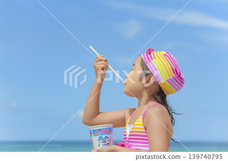 一個女孩在夏日海灘上吃刨冰 一個女孩在夏日海灘上吃刨冰 139740795