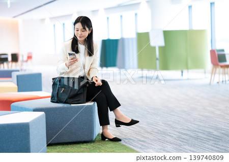 Woman operating a smartphone Woman operating a smartphone 139740809